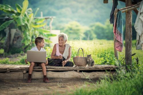 Kind dat oma het internet toont met een laptop.